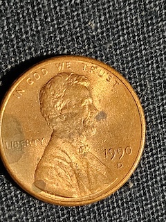Close-up macro photograph of a 1990 Lincoln penny doubled die error showing doubling on the date numerals or IN GOD WE TRUST lettering
